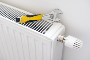 A wrench sitting atop a broken heater